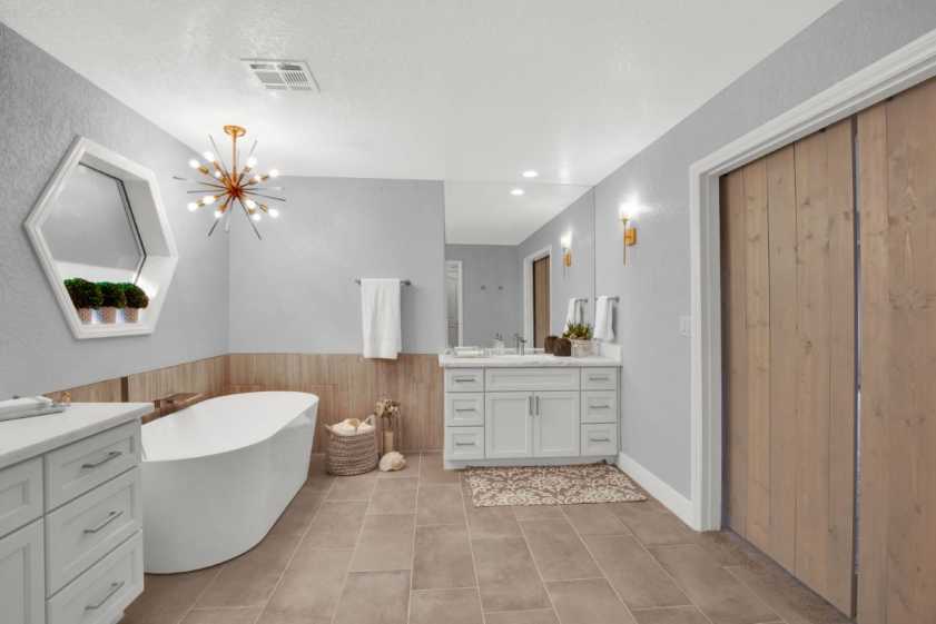 bathroom with tub and modern light fixture