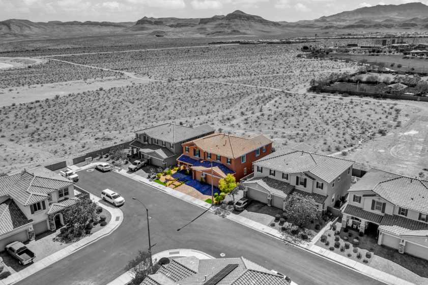 drone photograph of house in desert with house highlighted and the rest of the picture is black and white.