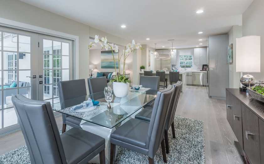 Dining room photograph with white flower vase on table with table settings